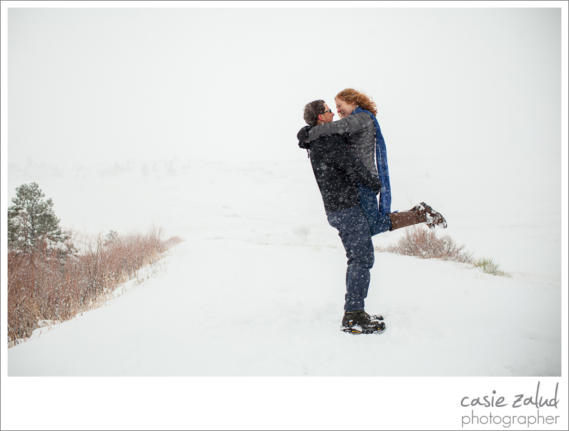 a man picking up and spinning his wife to be in a snowstorm