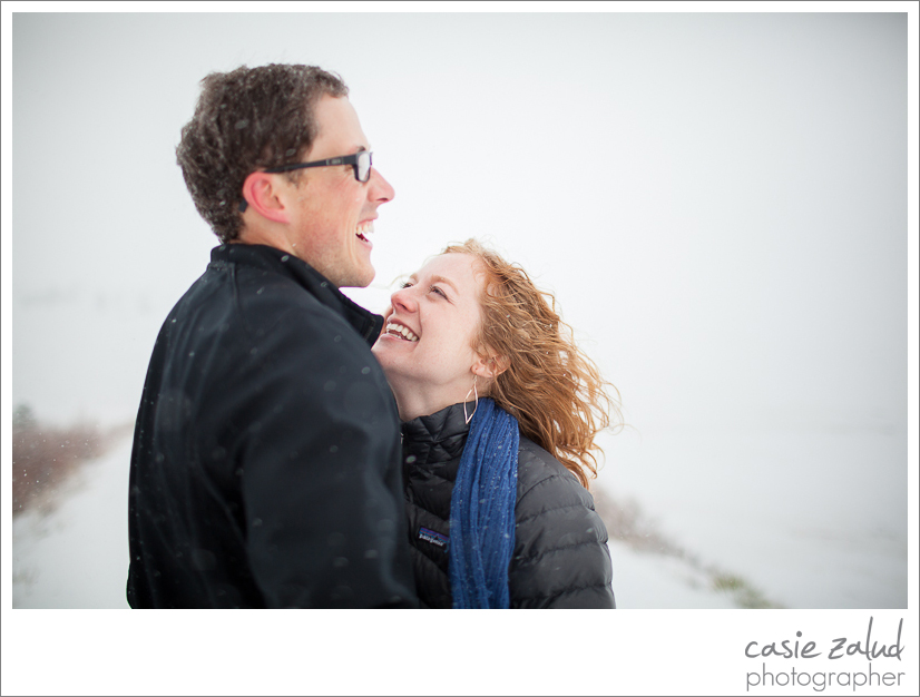 engaged couple laughing in snowstorm at Daddy Draw trail in Boulder