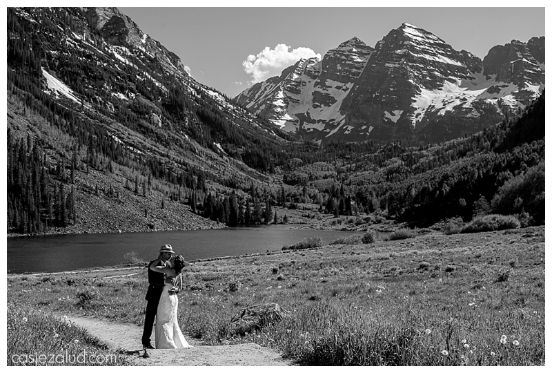 BW wedding couple portrait on trail in front of the Maroon Bells as they kiss