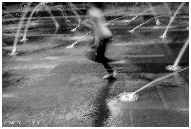 blurred photo of a girl running through a splash pad 