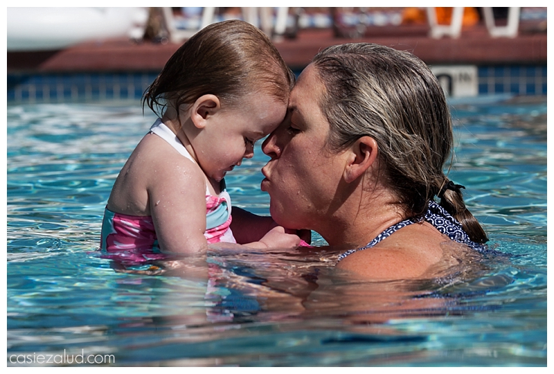 Close up of a mom about to kiss her toddler in a pool