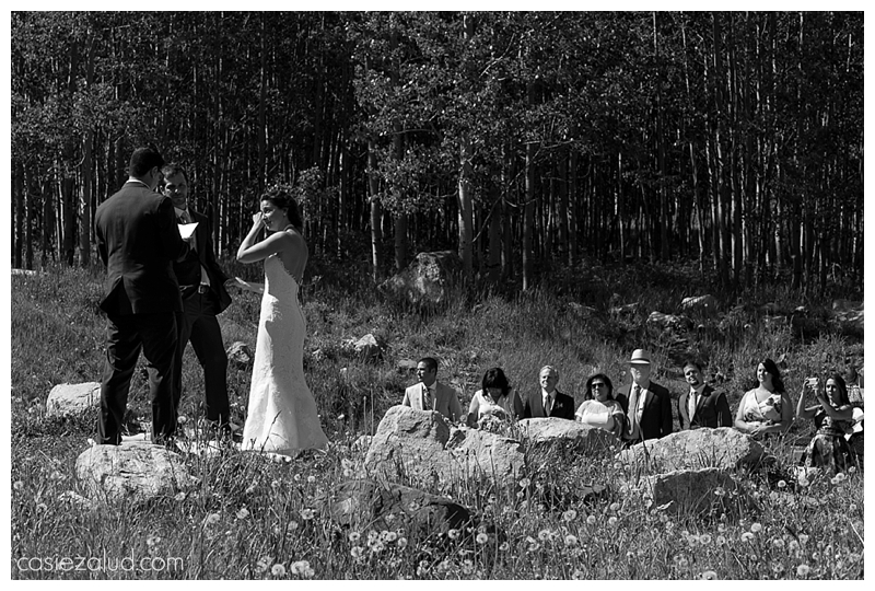 a bride wiping a tear from her face as she weds her best best friend before her family at the Maroon Bells Amphitheater