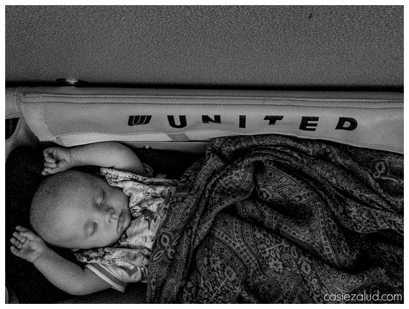 Infant sleeping in a United airlines bassinet
