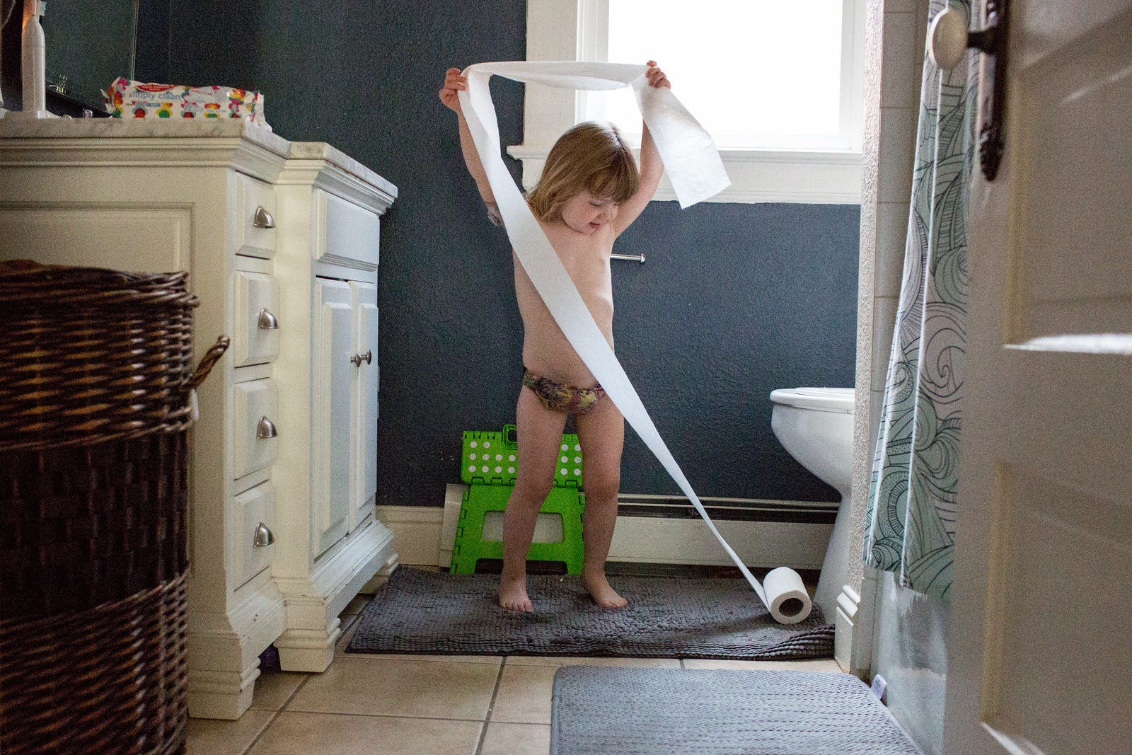 testimonial of documentary family photography session toddler in underwear pulling toilet paper off roll in Denver Colorado