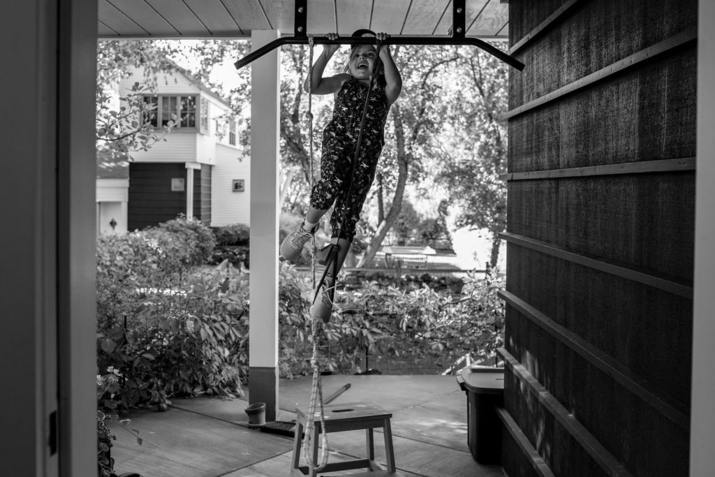 little girl tries to do a pull up during her basalt family session