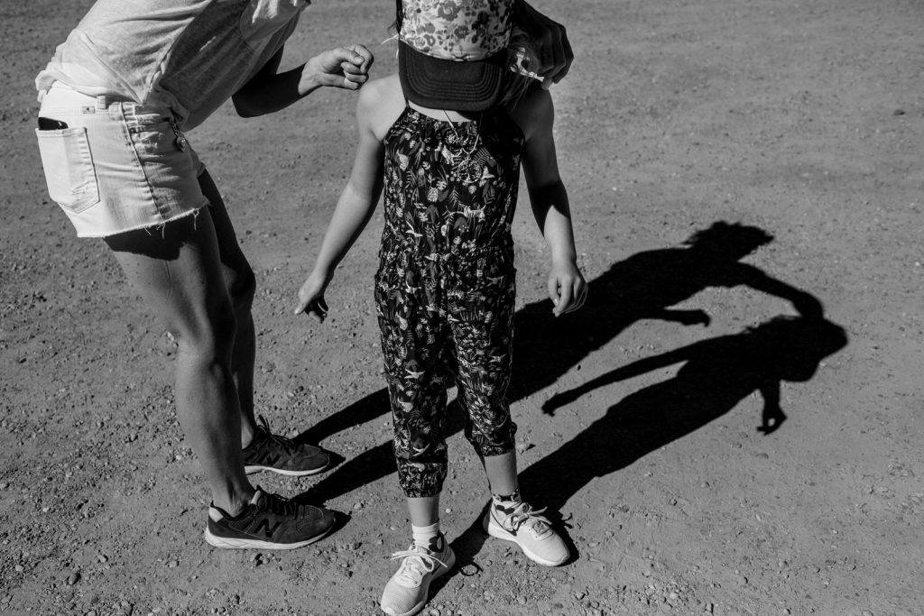 shadow image of mom putting sunscreen on her daughter's shoulders during a vacation in colorado