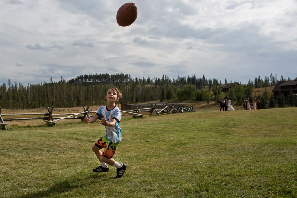 kid just about to catch a football on the lawn at Devil's Thumb Ranch