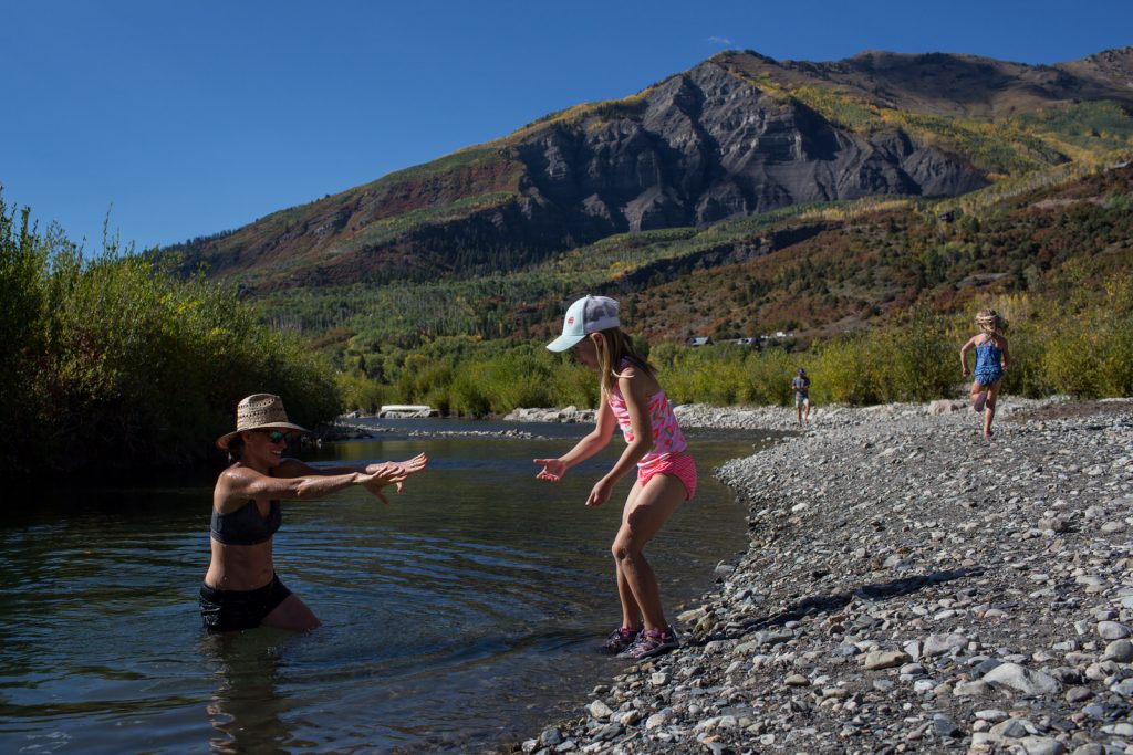 little girl helping mom get out of river during marble vacation session summer